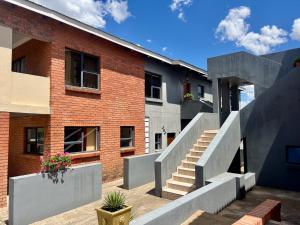 a brick building with stairs in front of it at Kairos Guest House in Maseru