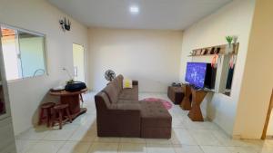 a living room with a couch and a flat screen tv at Casa da Daniella in Conceição do Araguaia