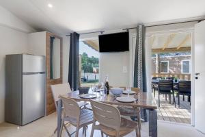 a dining room with a table and a refrigerator at Mobilehome Evasion 54 in Saint-Gervais