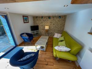 a living room with a green couch and chairs at Ty Heole House in Plouézec