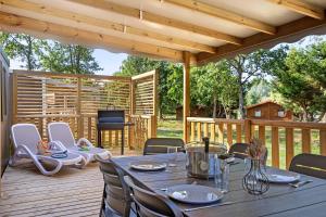 a patio with a table and chairs on a deck at Mobilehome Evasion 54 in Saint-Gervais