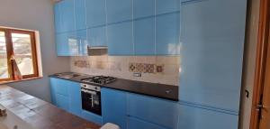 a kitchen with blue cabinets and a stove at Casa Marel in Stromboli