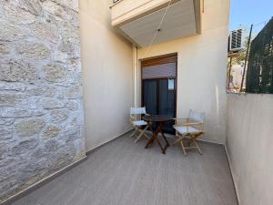 a patio with a table and chairs on the side of a building at Afytos Family Apartment in Afitos