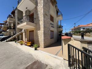a apartment building with a balcony and a street at Afytos Family Apartment in Afitos