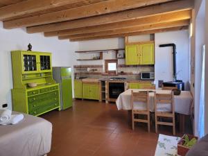 a kitchen with green cabinets and a table with chairs at Casa Sole in Ceniga