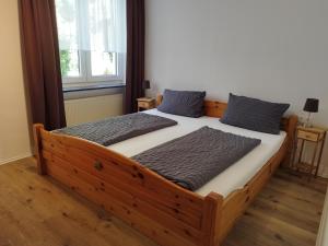 a bedroom with a wooden bed with two pillows at Pension Chapeau-Claque in Cochem +23 photos