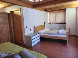 a bedroom with two beds and a wooden ceiling at Casa Sole in Ceniga