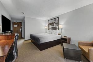 a hotel room with a bed and a couch at Super 8 by Wyndham Dubuque in Dubuque +20 photos