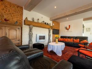 a living room with leather furniture and a fireplace at Anc. Seigneurie de Boucaut in Leuze-en-Hainaut