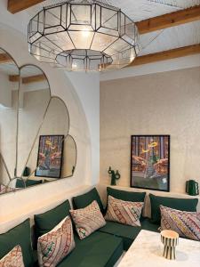 a living room with a green couch and a chandelier at Riad El Badun in Marrakesh