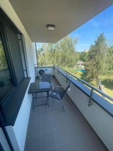 a balcony with a table and chairs and a window at Apartmán Formula Trenčín in Trenčín