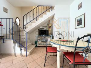 a living room with a staircase and a table and chairs at Villa Calentana in Macari