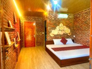 a bedroom with a bed in a brick wall at Nếp homestay in Làng Xa