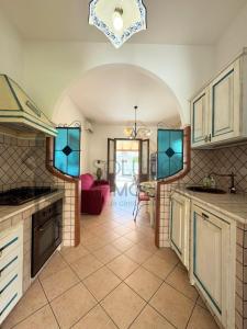 a large kitchen with a table and a red couch at Villa Calentana in Macari