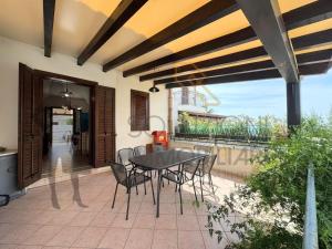 a patio with a table and chairs and a balcony at Villa Calentana in Macari