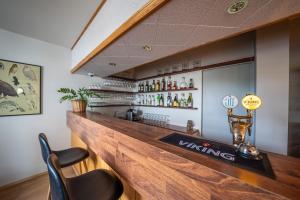 a bar with a wooden counter and some chairs at Bakkaflöt Guesthouse in Varmahlid
