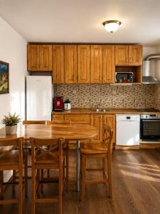 a kitchen with wooden cabinets and a wooden table and chairs at UMANI Retreat in Buşteni +95 photos