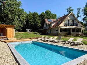 a swimming pool in front of a house at La Casa Baccata in Sarlat-la-Canéda