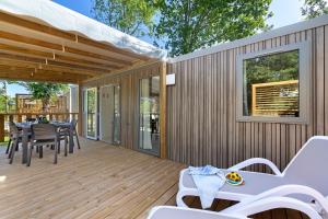 a wooden deck with a table and chairs on it at Mobilehome Evasion 51 in Saint-Gervais