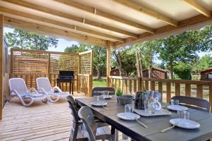 a wooden deck with a table and chairs and a piano at Mobilehome Evasion 51 in Saint-Gervais