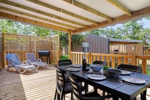 a patio with a table and chairs on a deck at Mobilehome Evasion 50 in Saint-Gervais