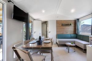 a living room with a table and a couch at Mobilehome Evasion 50 in Saint-Gervais