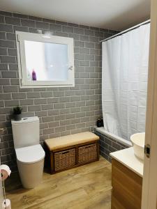 a bathroom with a toilet and a sink and a window at Casa Roa in Altea