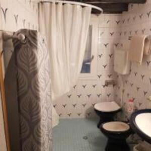 a bathroom with two toilets and a sink and a shower at Parma, Antico Studio dietro al Battistero in Parma