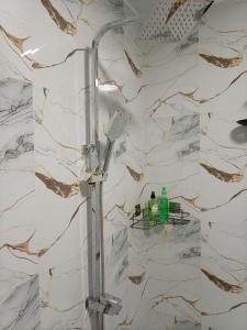 a shower in a bathroom with a marble wall at Rainforest Nature Resort - Sinharaja in Deniyaya