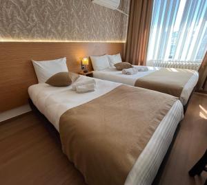 a hotel room with two beds and a window at Hotel Gazi in Gaziantep