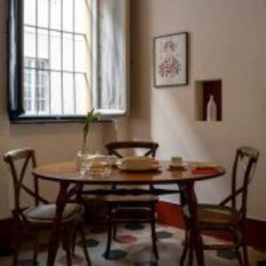 a table and chairs in a room with a window at Parma, Antico Studio dietro al Battistero in Parma