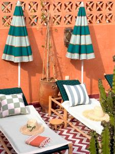 a patio with two chairs and two umbrellas at Riad El Badun in Marrakesh +54 photos