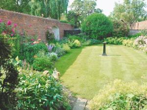 a garden with a lawn with a birdbath in it at Saltersgate in Pickering