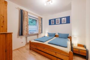 a bedroom with a wooden bed with blue pillows at Ferienhaus Napoleon in Waldmünchen