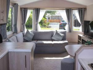 a living room with a couch and a table at Sarnfaen Static - Uk52097 in Llanddwywe
