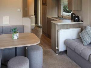 a living room with a table and chairs in a caravan at Sarnfaen Static - Uk52097 in Llanddwywe