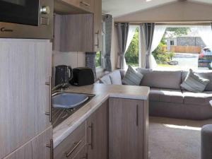 a caravan kitchen and living room with a couch at Sarnfaen Static - Uk52097 in Llanddwywe