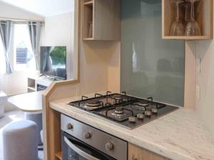 a kitchen with a stove top in a kitchen at Sarnfaen Static - Uk52097 in Llanddwywe +5 photos