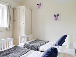 two twin beds in a room with white walls at Rudda Farm Cottage - Uk2492 in Staintondale +6 photos