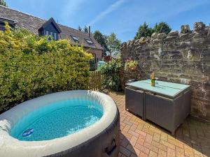 a large hot tub in a backyard with a hot tub at The Boyne Arms Cottage in Burwarton