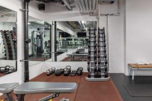 a gym with a bunch of equipment in a room at Leman Locke in London