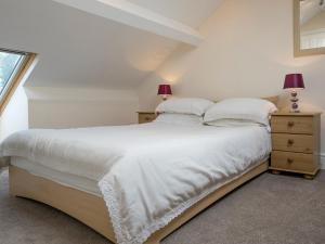 a bedroom with a white bed and a window at Esthwaite in Windermere