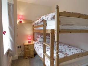 a bedroom with two bunk beds and a lamp at Esthwaite in Windermere