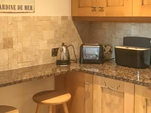 a kitchen counter with a tea kettle and a toaster at Ebba's Neuk in Beadnell +4 photos