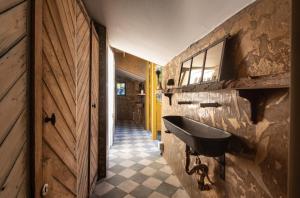 a bathroom with a sink on a stone wall at Tiny Wineyhouse 3 in Zennewijnen