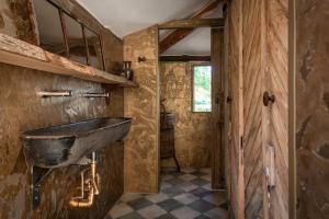 a bathroom with a stone sink in a room at Tiny Wineyhouse 3 in Zennewijnen