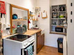 a small kitchen with a stove and a sink at Bloomer's Bothy in Askrigg