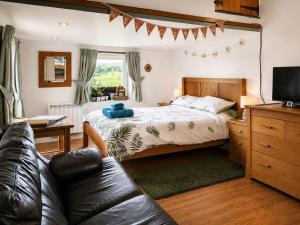 a bedroom with a bed and a couch at Bloomer's Bothy in Askrigg