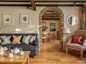 a living room with a blue couch and a table at Hungate Garden Cottage in Pickering +5 photos