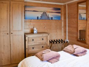 a bedroom with two beds and a dresser at Algwen Cabin in West Walton